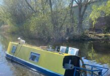 Nordengland: Schwimmender Plattenladen Rubber Ducky gesunken Ein typisches Narrowboat aus England, welches in einem Kanal bei Manchester auf Grund liegt.