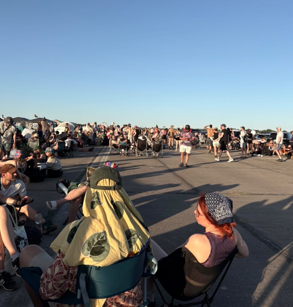 Tausende Festival Besucher:innen warten während der Evakuierung auf der Landebahn