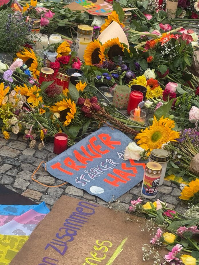Trauernde haben am Brandenburger Tor Blumen, Kerzen und Plakate hinterlassen (Foto: Laura Frech/Instagram: @vactivism)