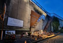 16 Jahre nach der Loveparade-Katastrophe: Duisburg erinnert an die 21 Todesopfer Die offizielle Gedenkstätte für das Loveparade-Unglück liegt am ehemaligen Güterbahnhof in Duisburg an der Mauer der Rampe am Karl-Lehr-Tunnel. Am 24. Juli 2010 starben dort 21 Menschen, über 500 wurden verletzt (Foto: Konni Wk/ Google)