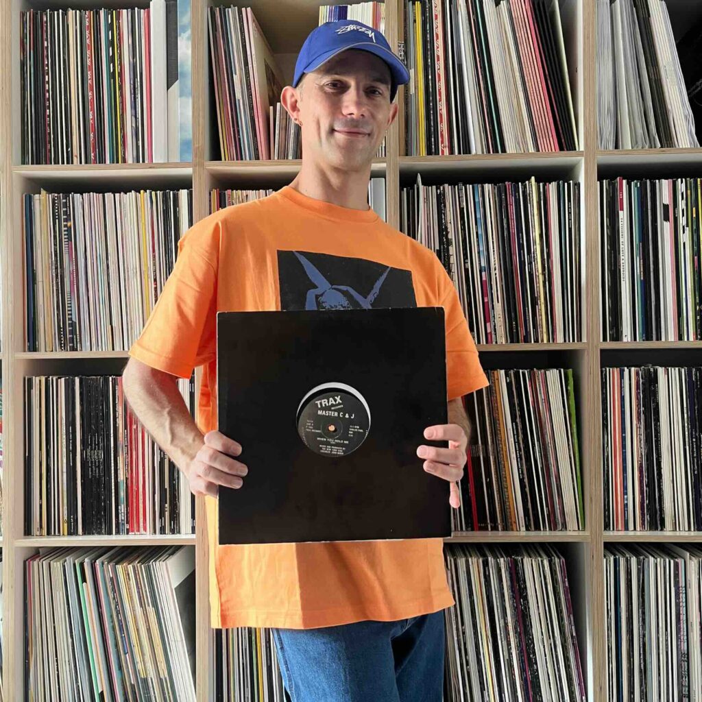 Massimiliano Pagliara vor seinem Plattenschrank mit einem Album von Master C & J.