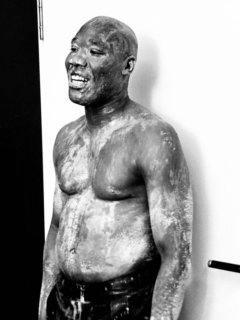Der Tänzer Rubén Nsue Mbese oberkörperfrei und voller Farbe.