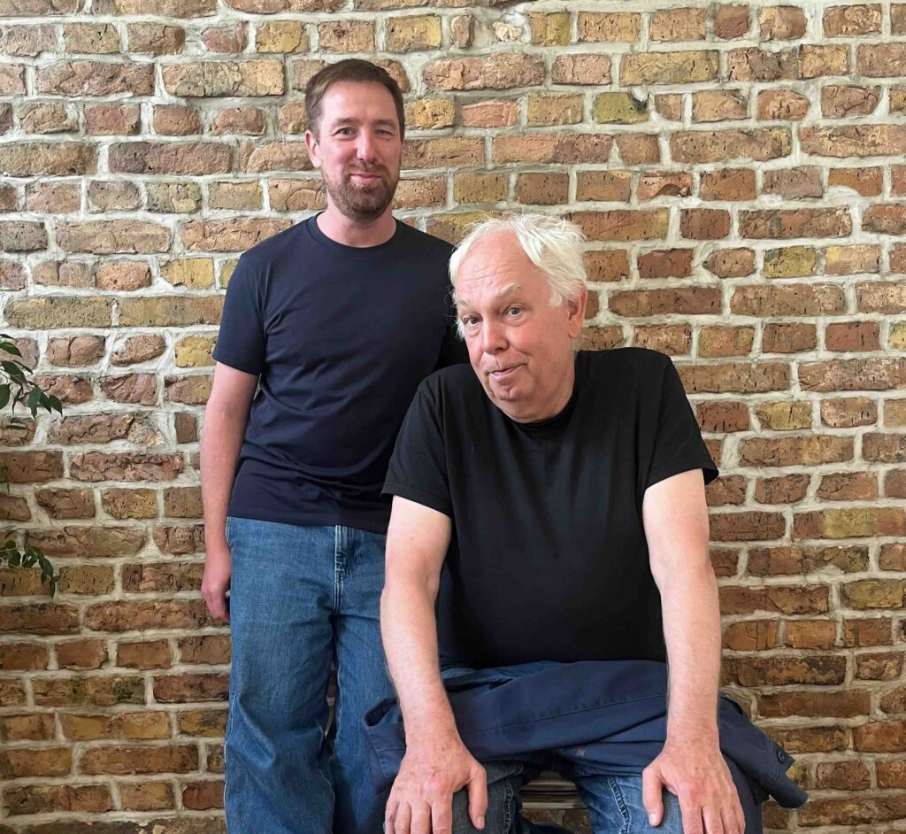 Marcel Weber und Dimitri Hegemann vor einer Ziegelwand